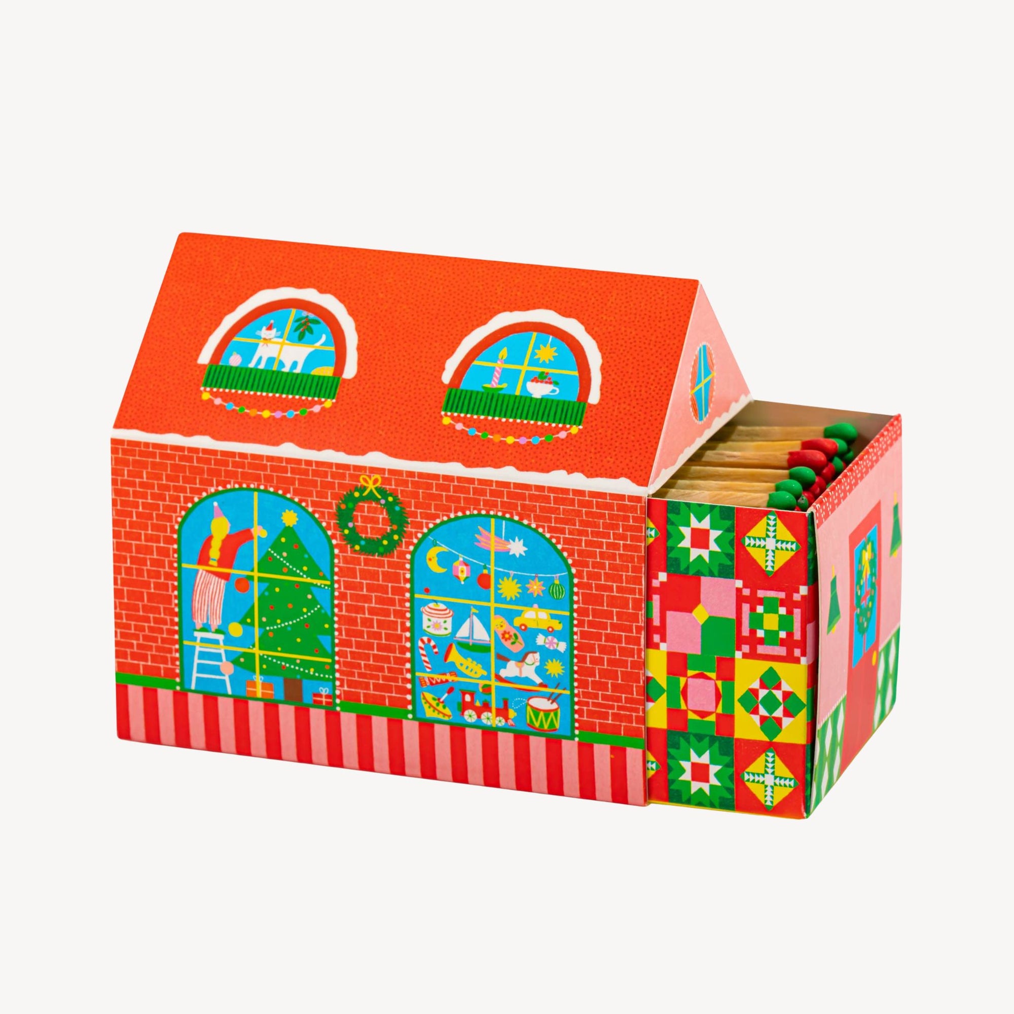Colorful matchbox in the shape of a  house with window designs on a white background