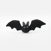 A small black felt bat toy with gray inner ears and white bead eyes, shown against a plain white background.