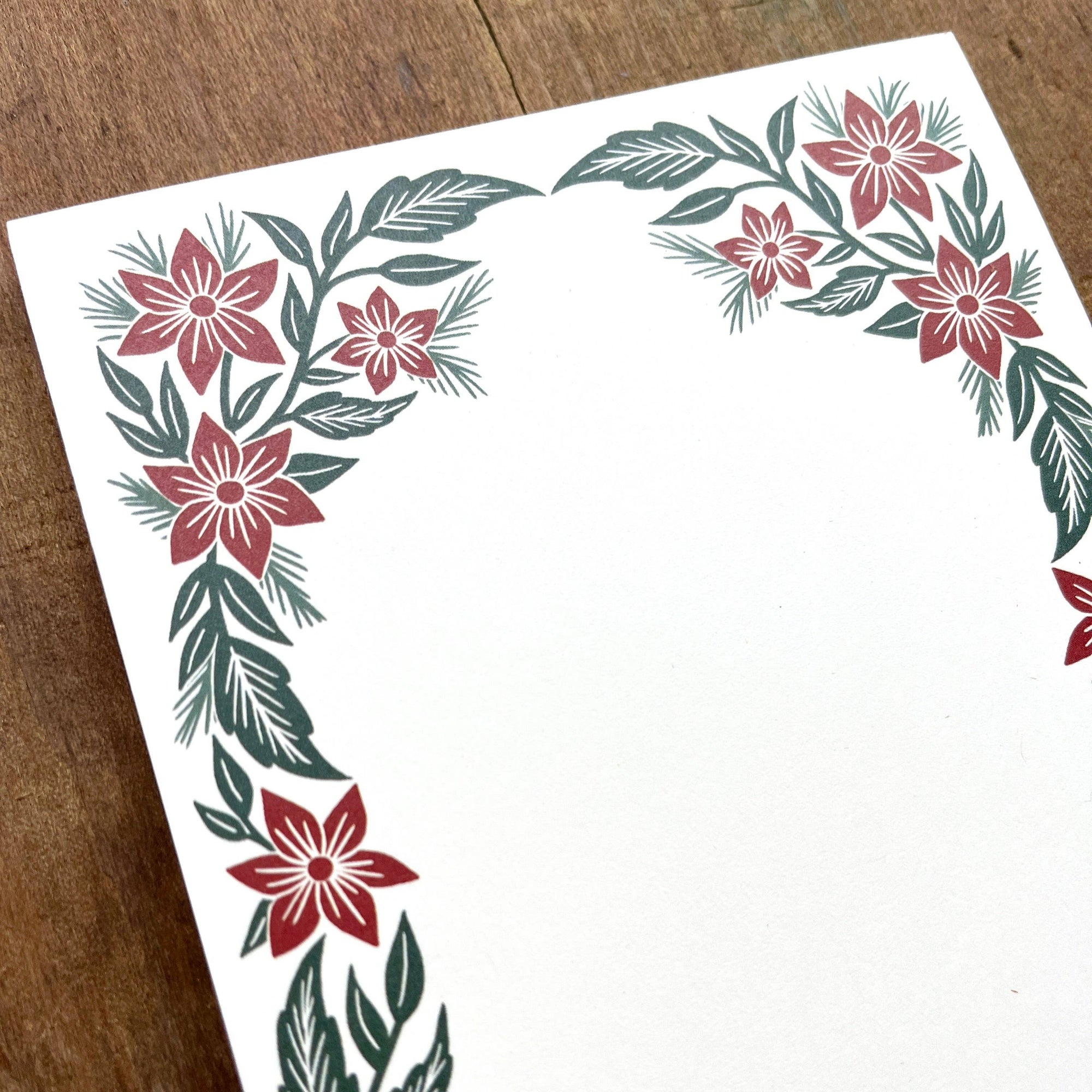 Decorative paper with floral border design on a wooden surface
