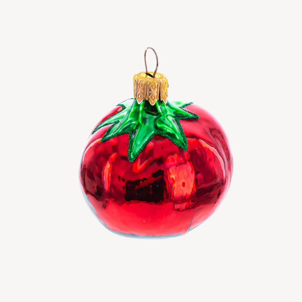 Glass tomato ornament on a plain background.
