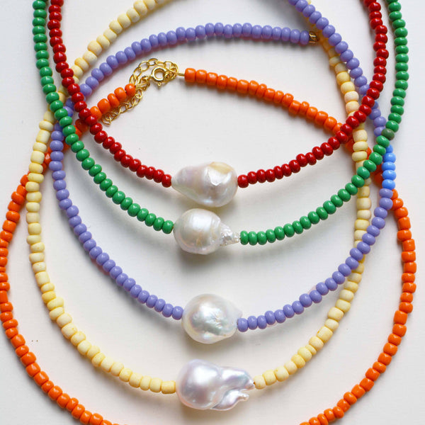 Colorful beaded necklaces with pearl accents on a white background