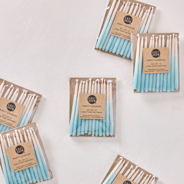 Packages of blue and white gradient candles on a light background
