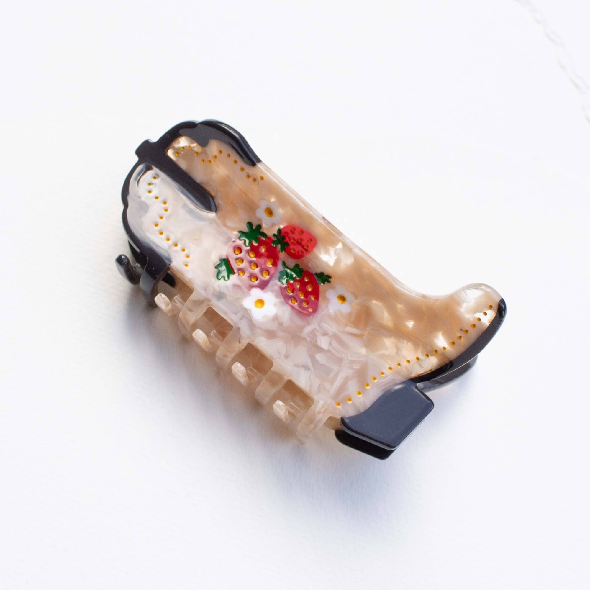 Decorative cowgirl boot hair clip with strawberry design on a white background