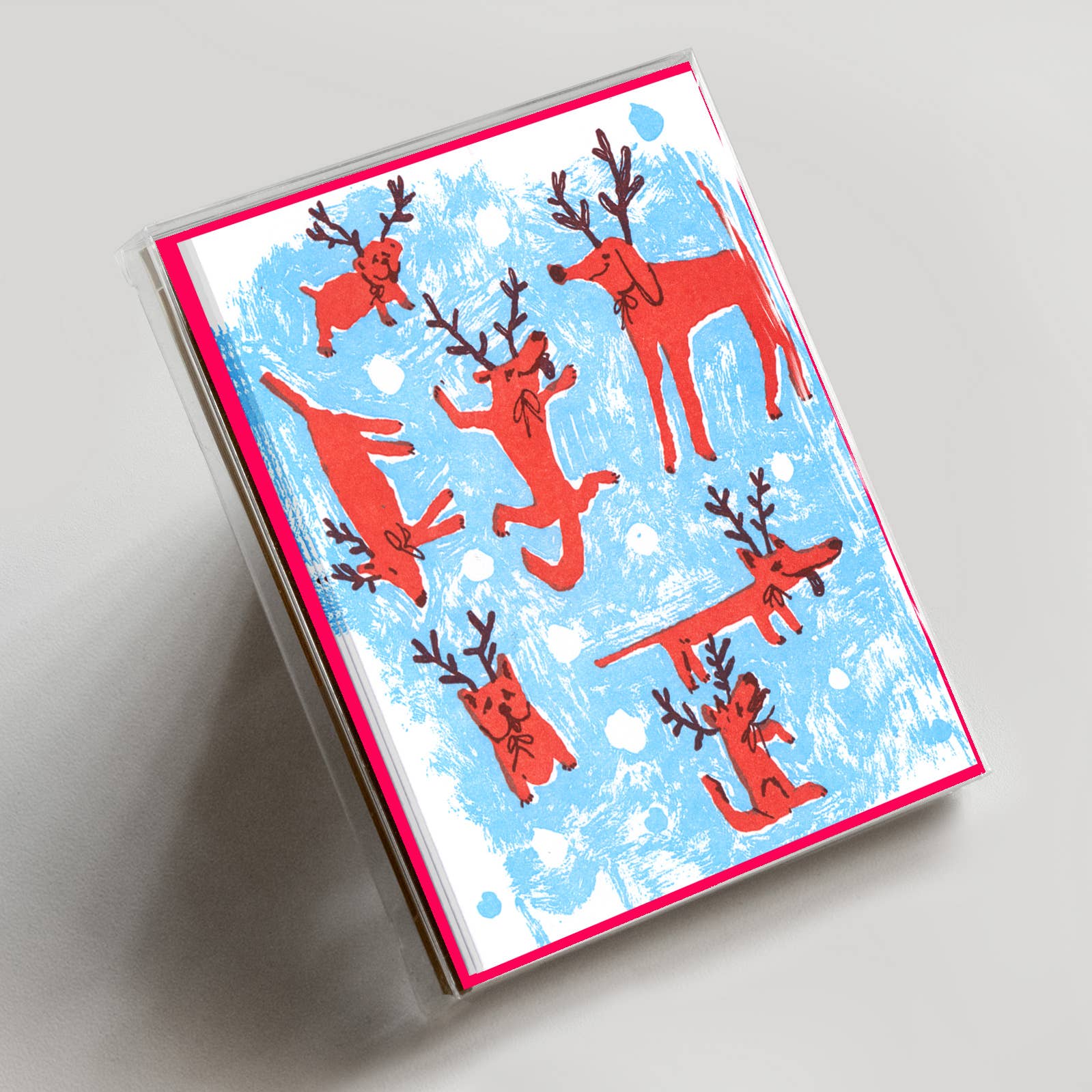Greeting card with red dogs with antlers illustrated on a blue and white patterned cover