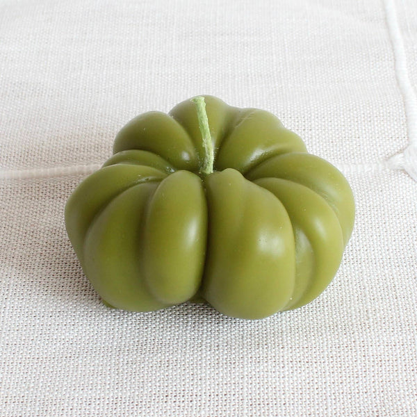Green fruit-like object on a textured white background
