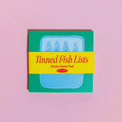 Sticky note pad with 'Tinned Fish Lists' text on a pink background