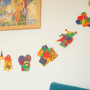 Colorful children's wall decorations on a white wall with a framed picture above.