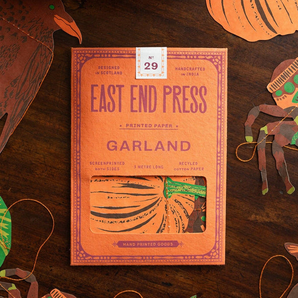 East End Press Garland package on a wooden surface with decorative pumpkins and ribbons.
