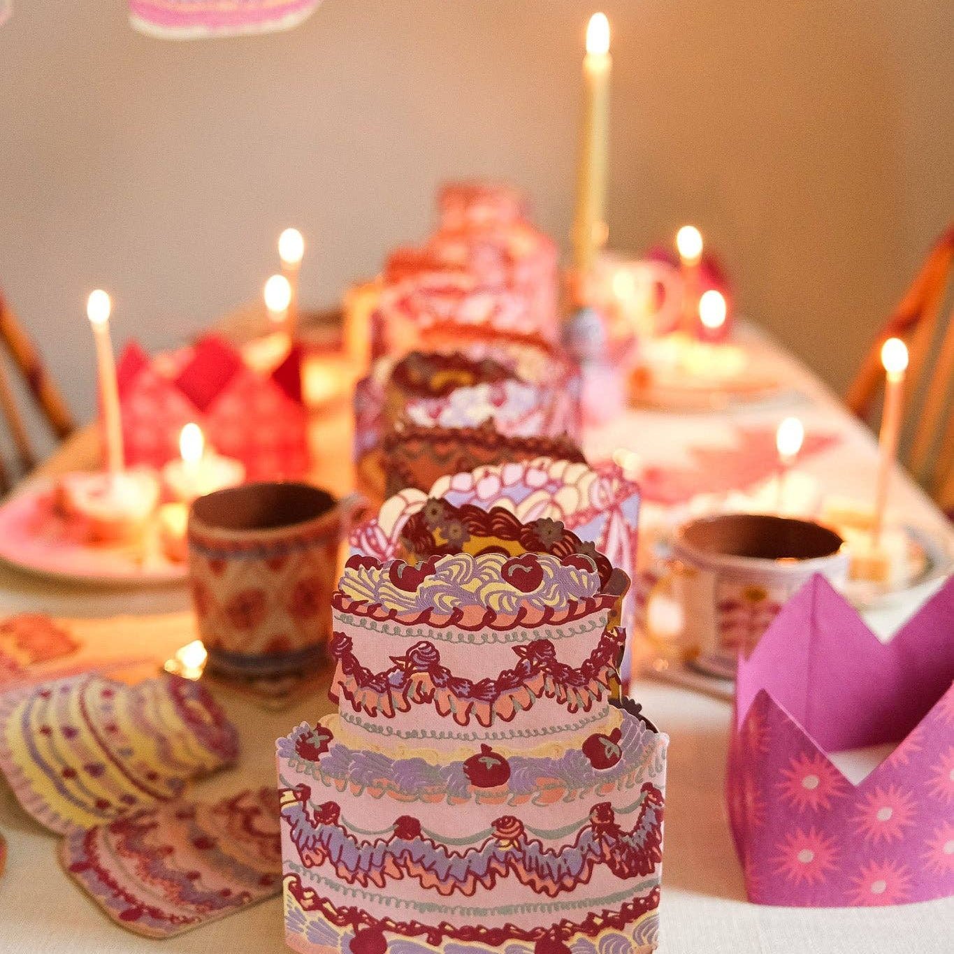 Decorative cake with candles on a table with a festive atmosphere.