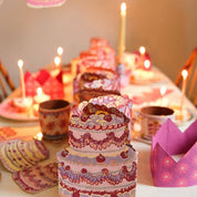 Decorative cake with candles on a table with a festive atmosphere.
