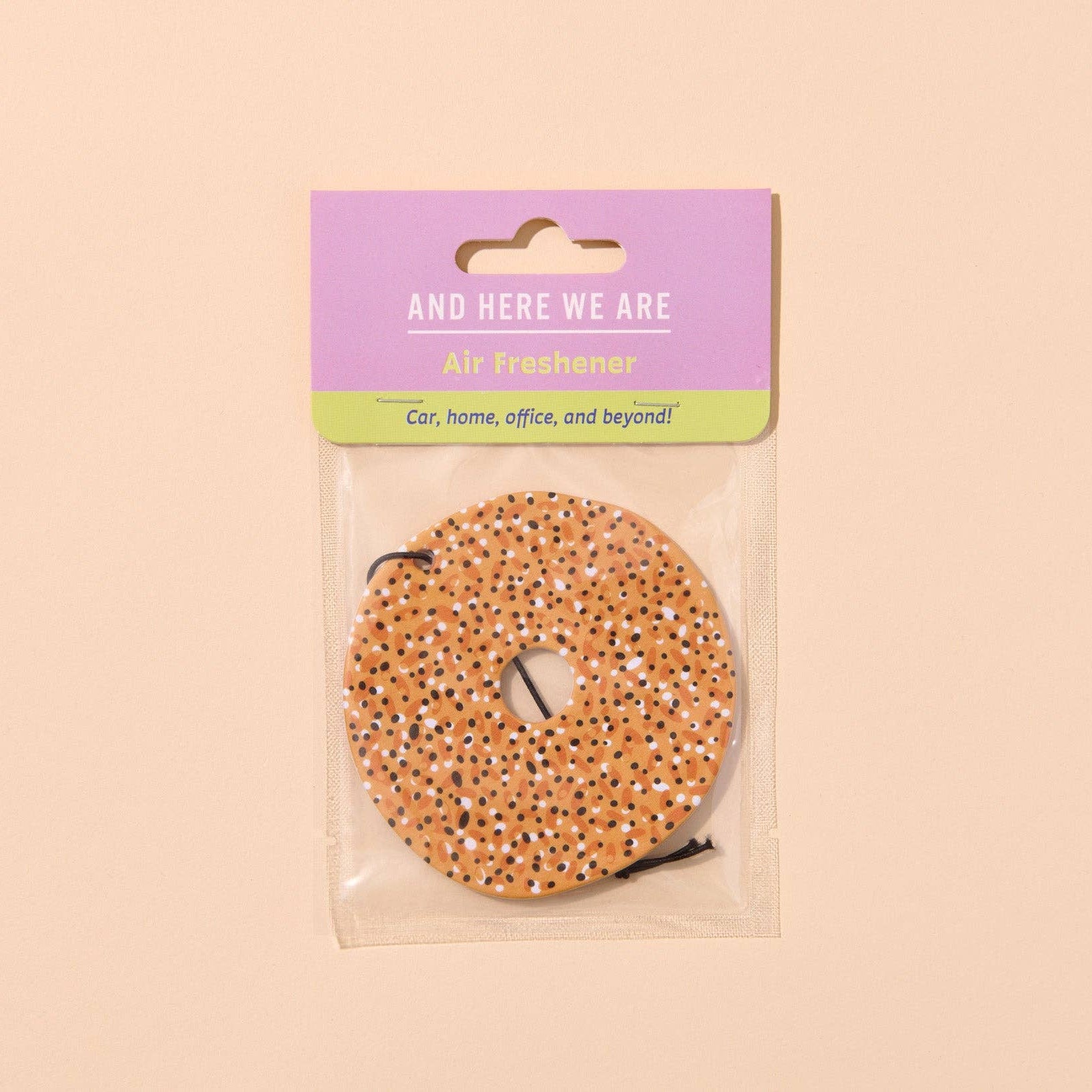 Everything bagel air freshener in clear packaging with purple label on beige background
