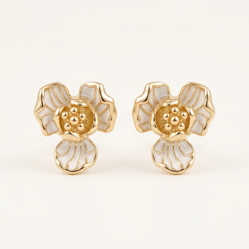 Pair of gold and white floral earrings on a light beige background