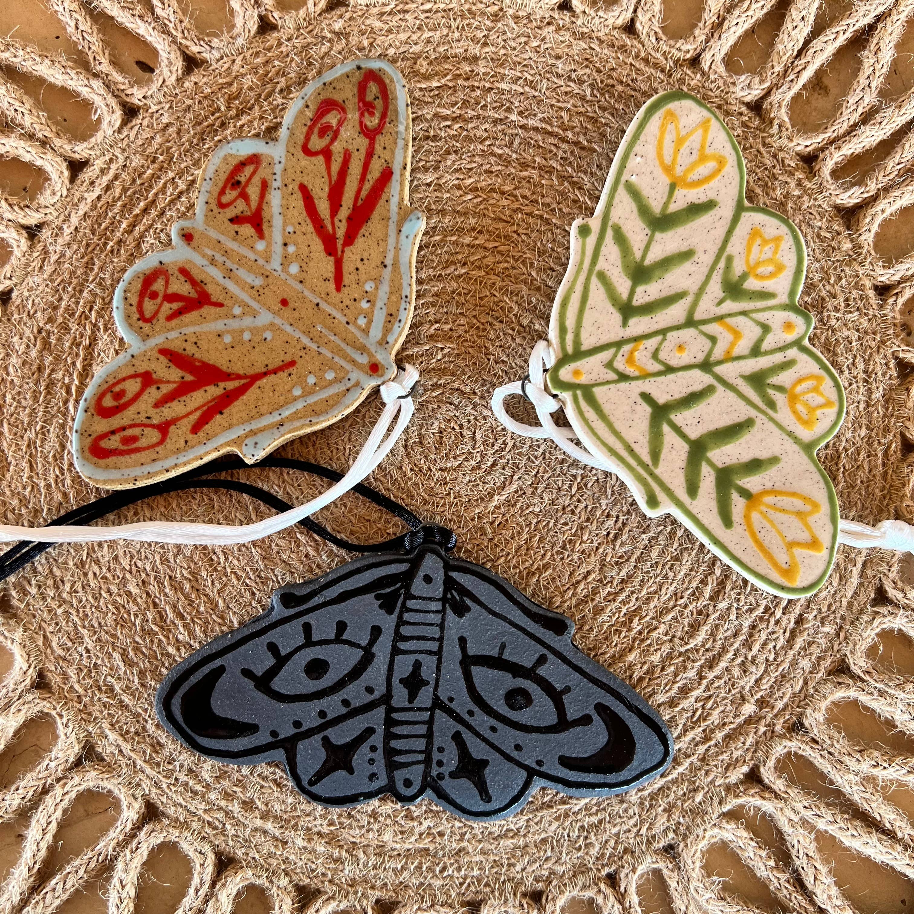 Colorful floral moth ceramic ornament by Tough Kitty Designs, detailed design with vibrant flower patterns on a ceramic surface.