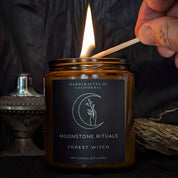 A hand lighting a candle with a match.