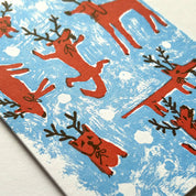 Pattern of red dogs with antlers on a blue and white background