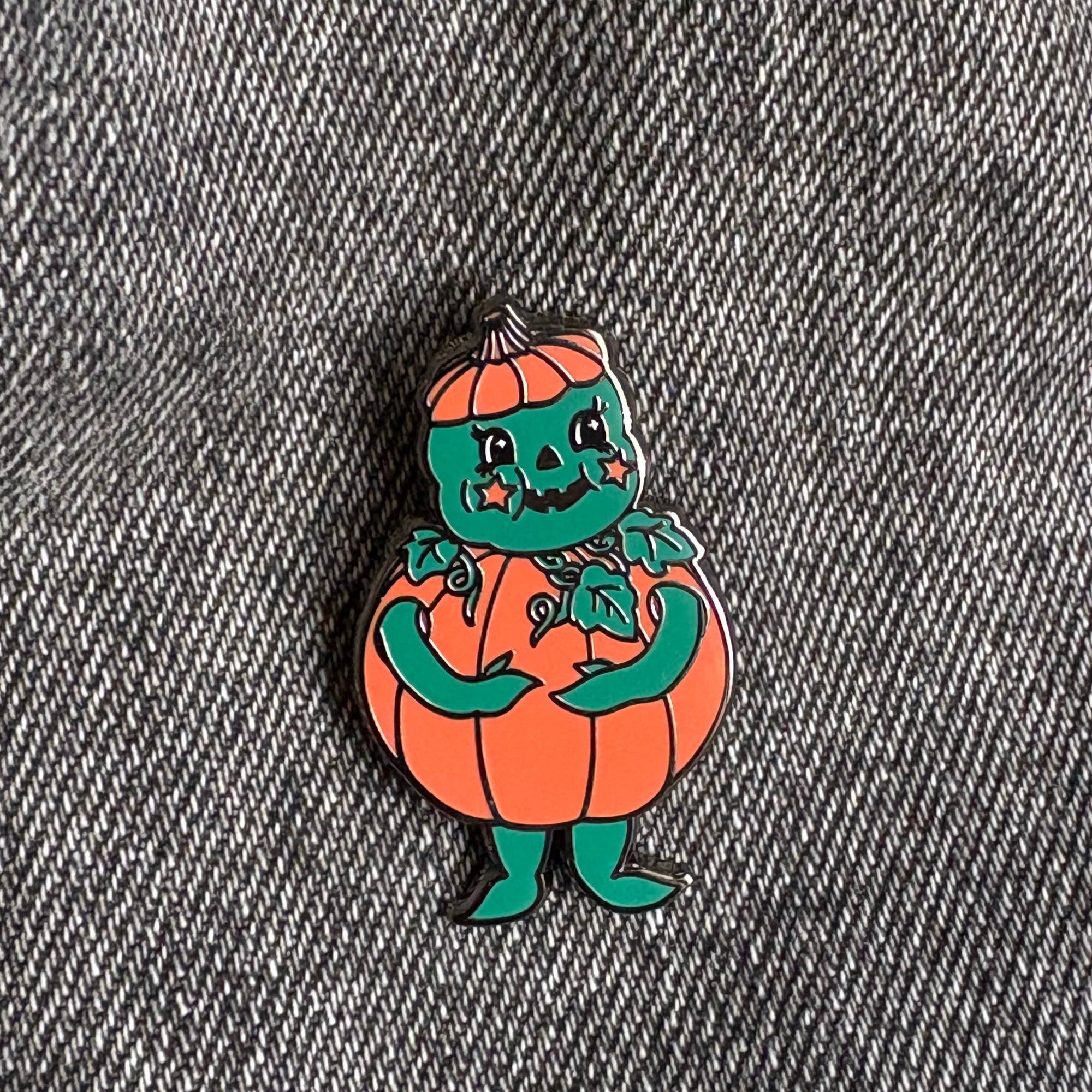Pumpkin character pin on a denim background