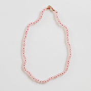 CanyonLeaf rose quartz gemstone necklace with a delicate pendant on a silver chain, displayed on a soft fabric background.