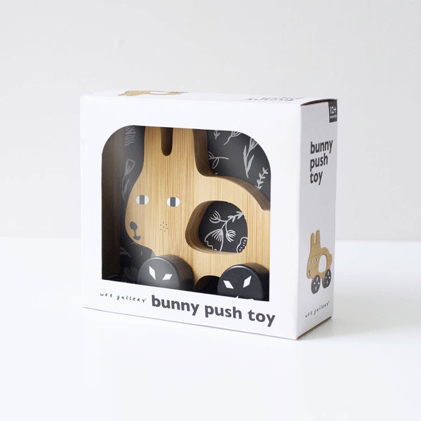 Wooden bunny push toy in a white box packaging on a white background