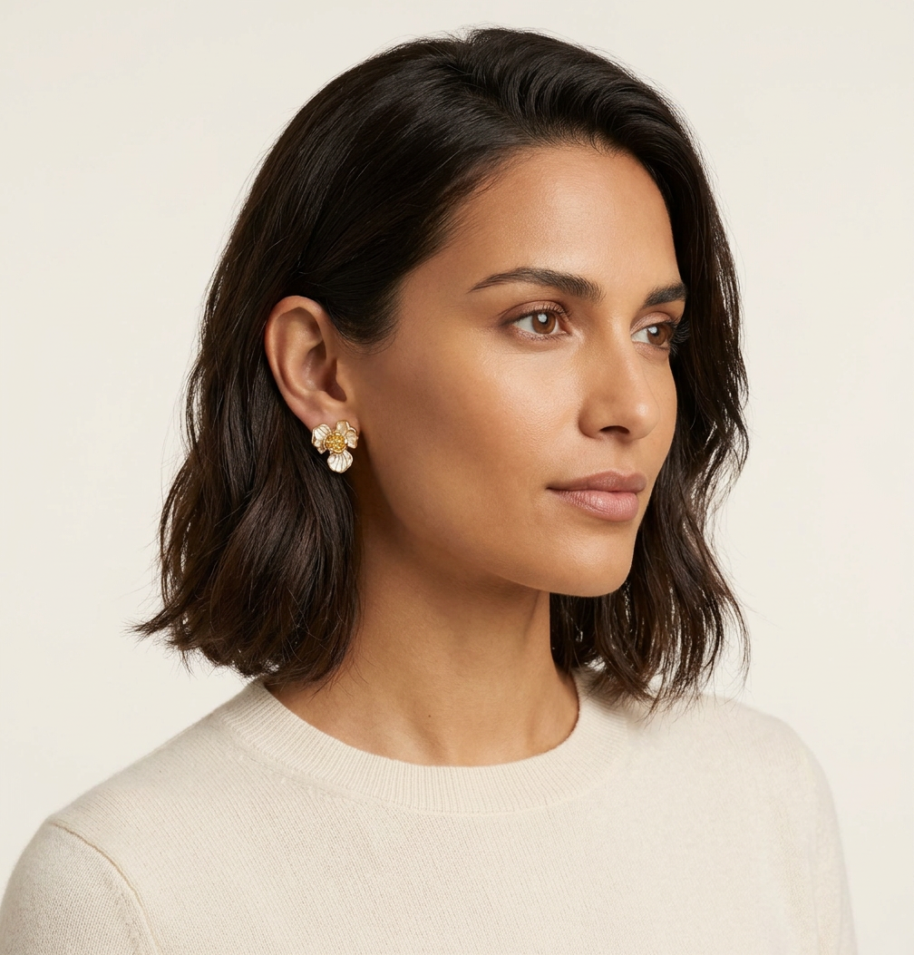 Woman wearing gold earrings with a neutral background
