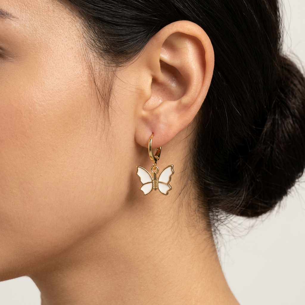 Butterfly-shaped earring worn by a person with a neutral background
