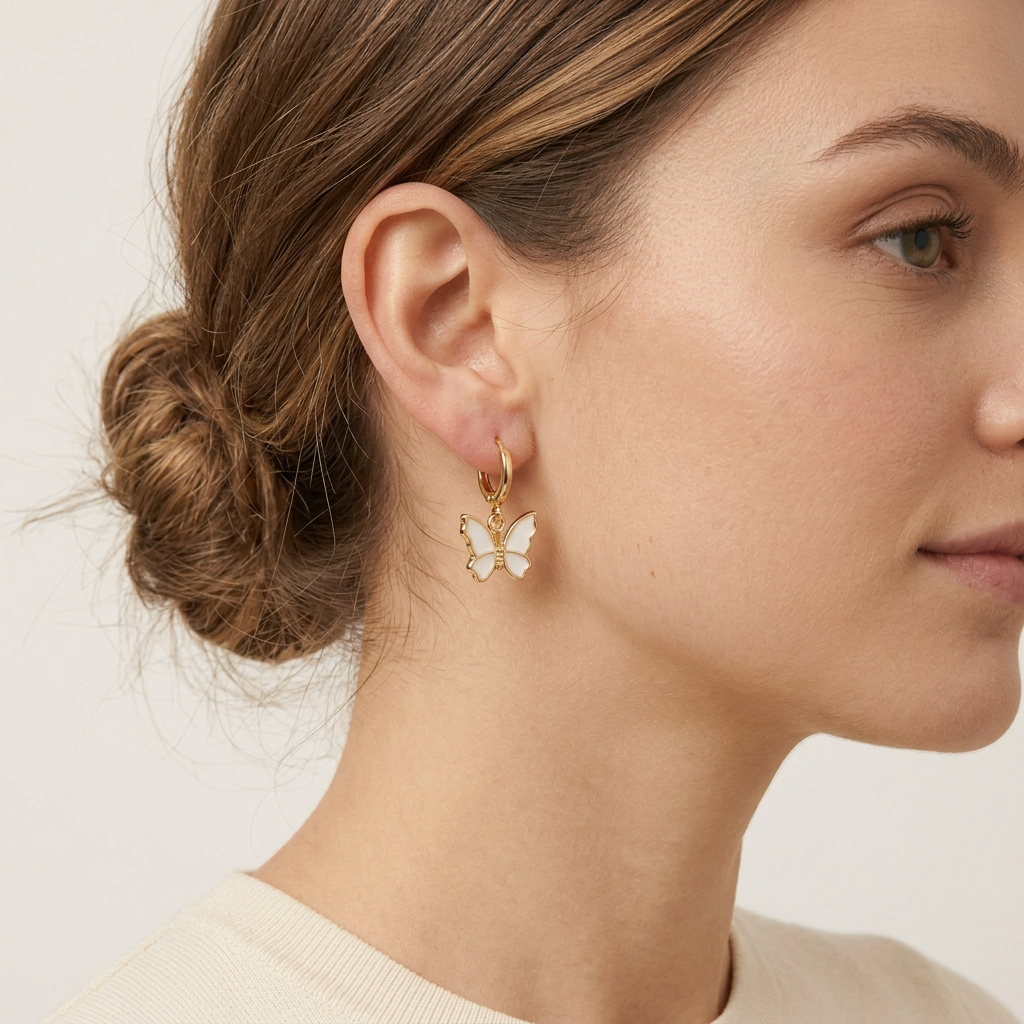 Close-up of a woman wearing a butterfly earring with a plain background