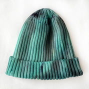 A green beanie hat against a white background.