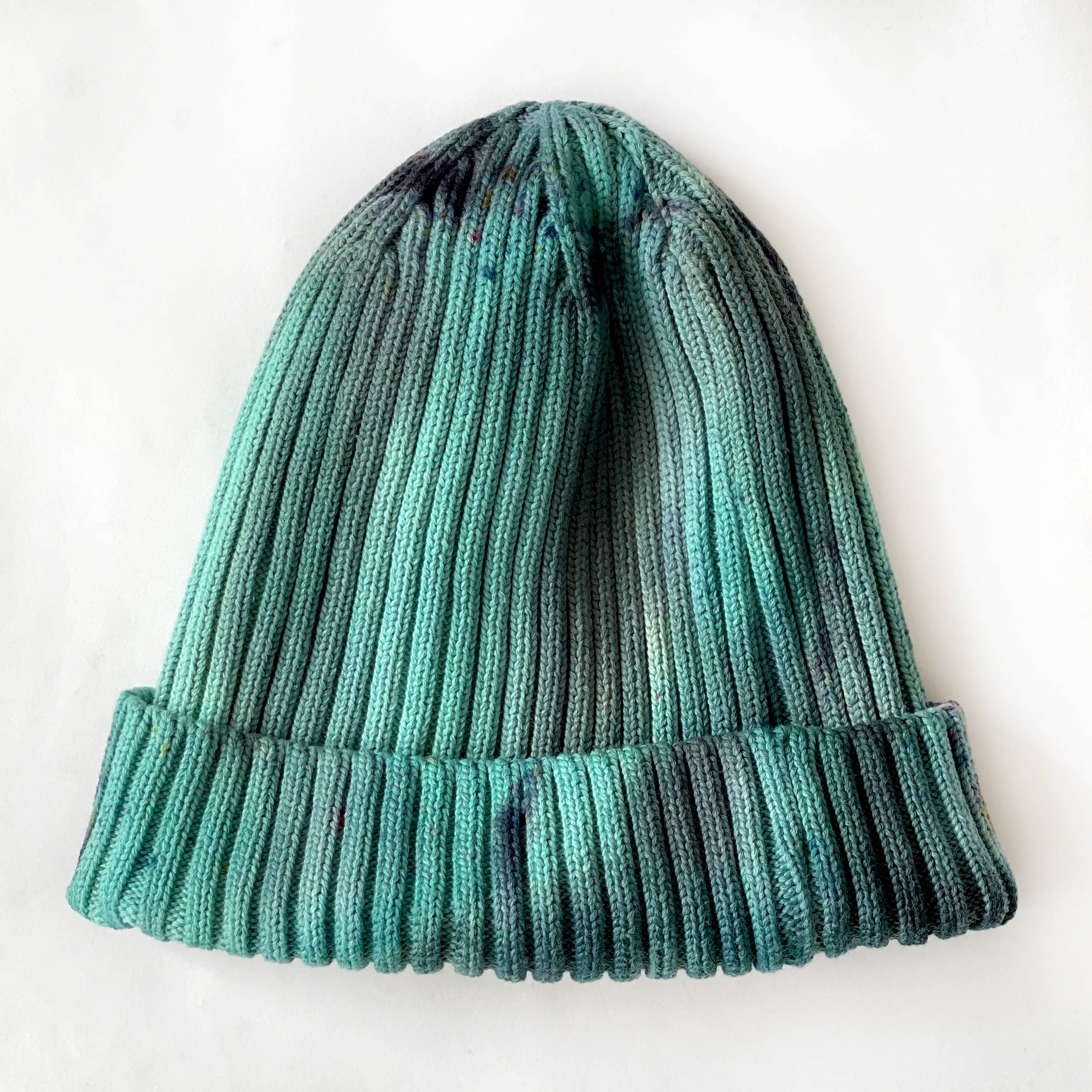 A green beanie hat against a white background.