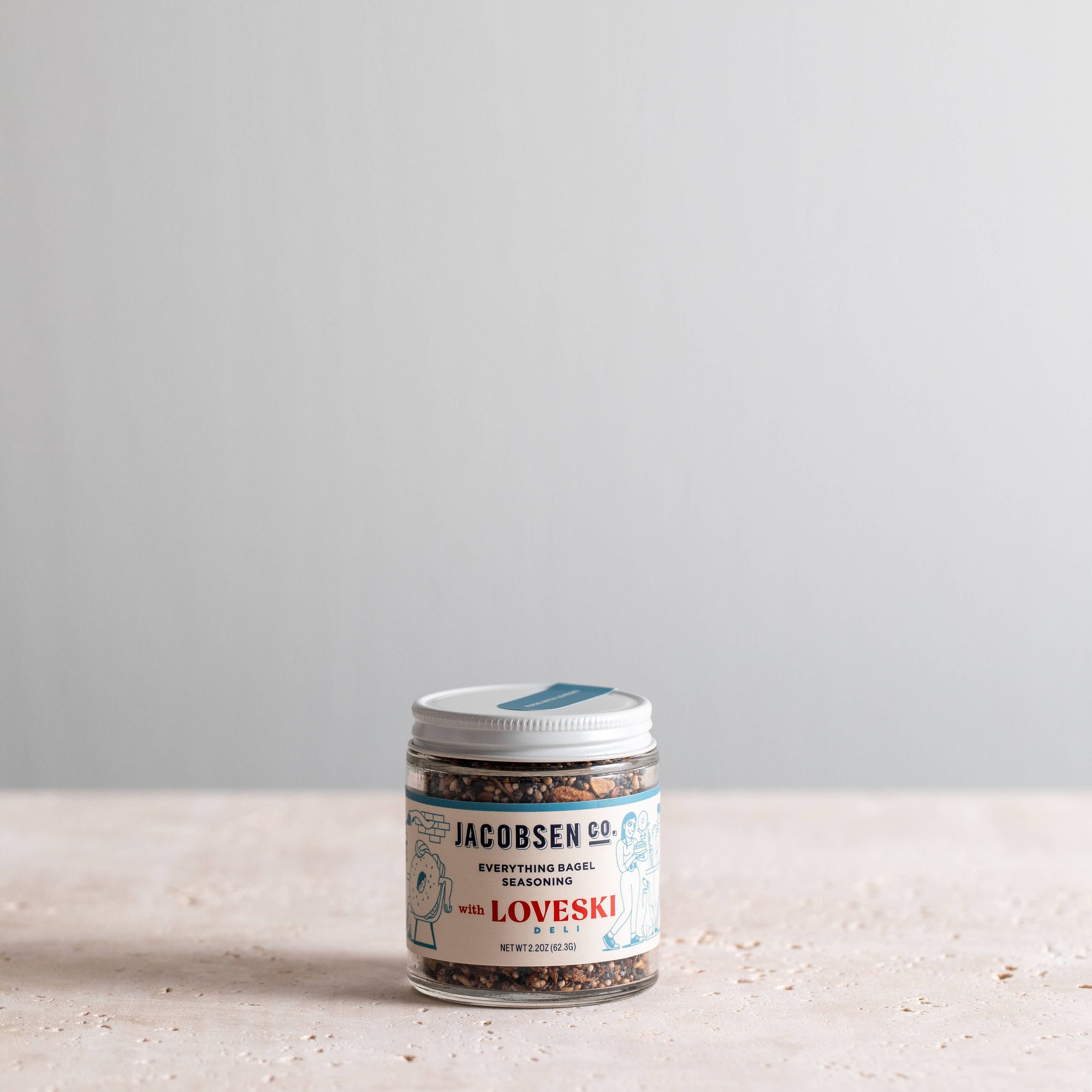 Jar of Jacobsen Everything Bagel seasoning on a light surface with a gray background