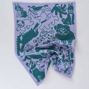 Purple tea towel with green animal illustrations on a white background