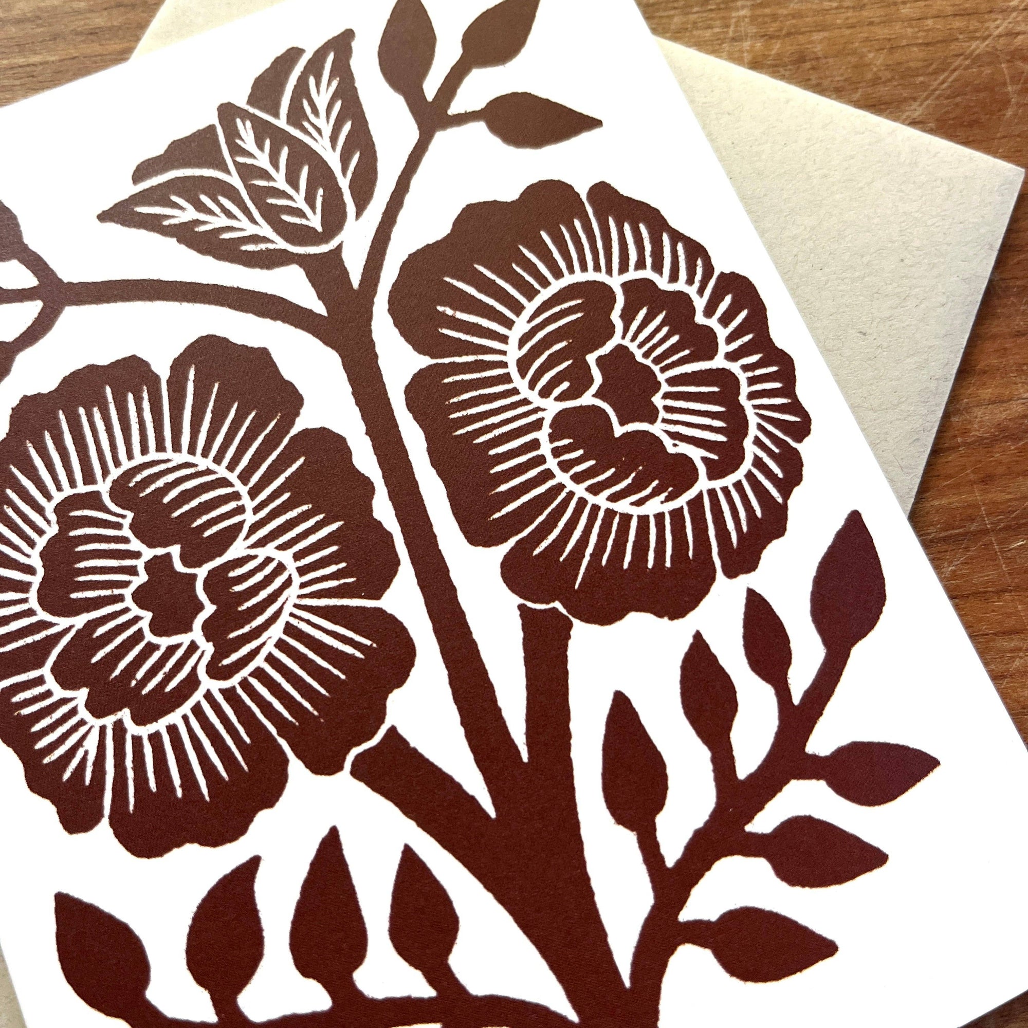 Card with brown floral design on a wooden surface