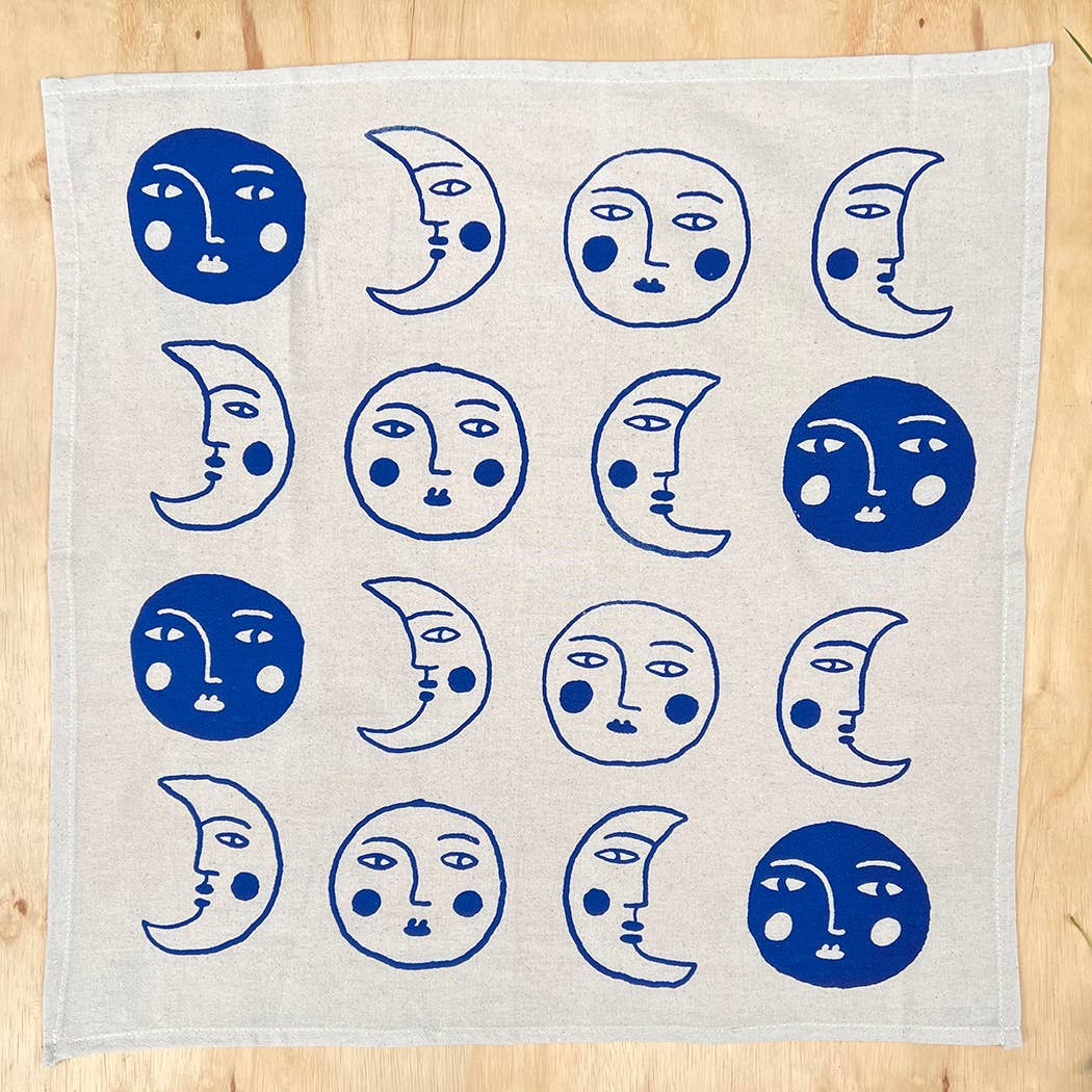 Fabric with blue moon and face patterns on a wooden surface