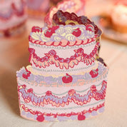 Decorative paper cake with pink and purple details on a neutral background