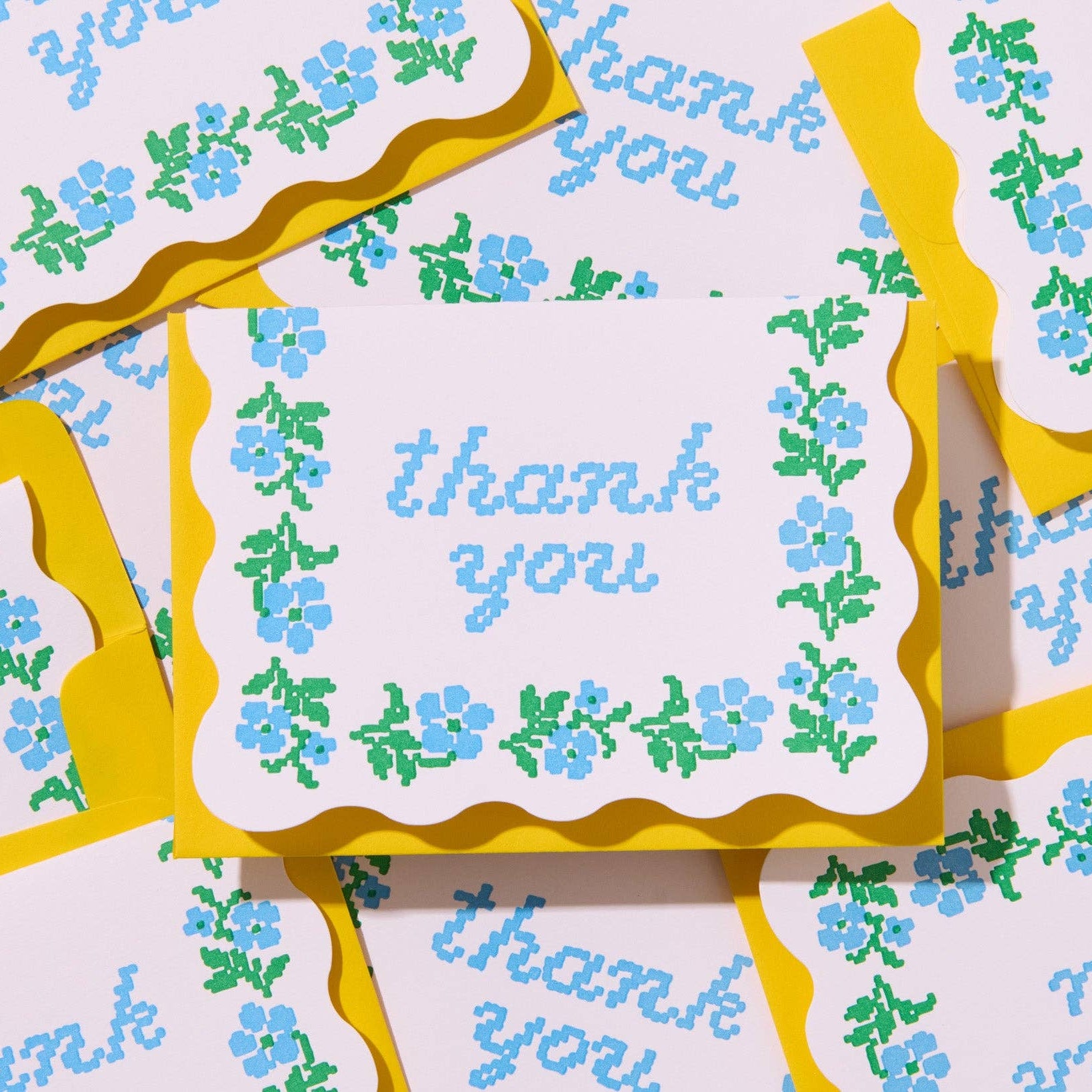 Packaging of 'thank you' cards with floral design and yellow borders.