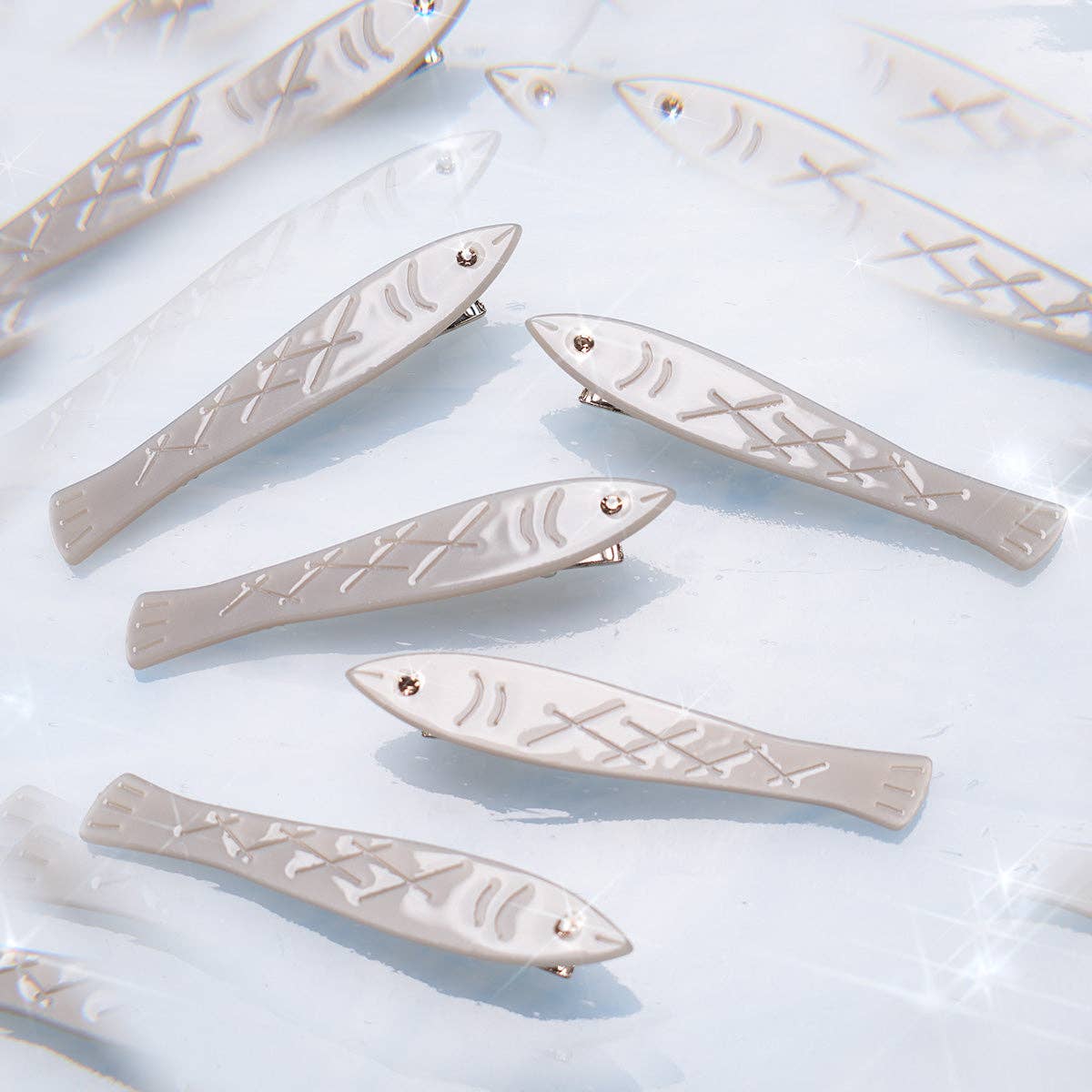 Fish-shaped hair clips on a light blue background