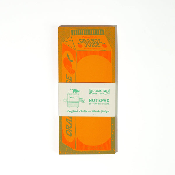 Notepad packaging designed to look like an orange juice carton with a 'Bromstad Printing Co.' branded tag.
