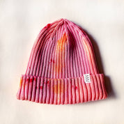 Knitted beanie with gradient color pattern on a light background