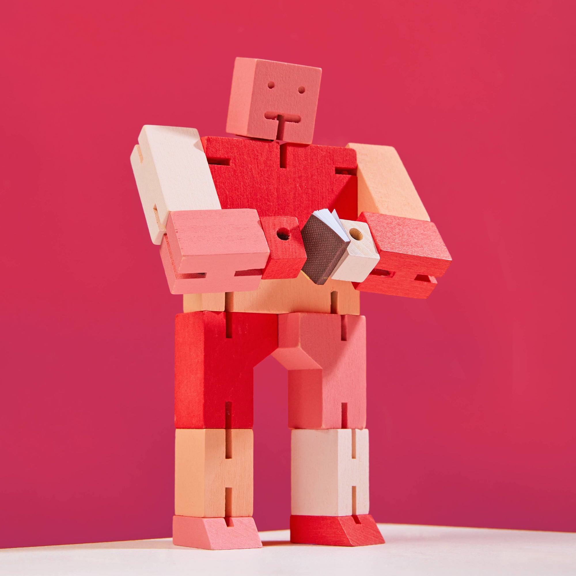 Red and pink robot toy against a red background