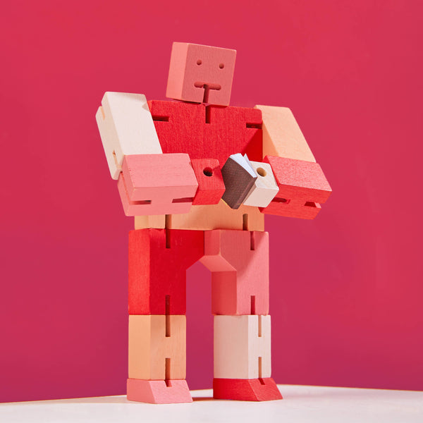 Red and pink robot toy against a red background