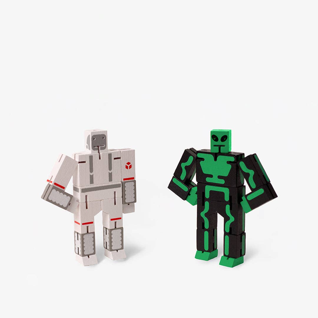 Two robot toy figures, one gray and one green with black, on a white background