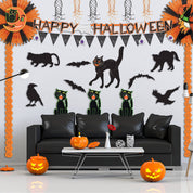 Halloween-themed living room with decorations including pumpkins, cats, and bats.