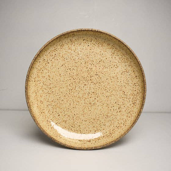 A beige ceramic noodle bowl with a speckled pattern.