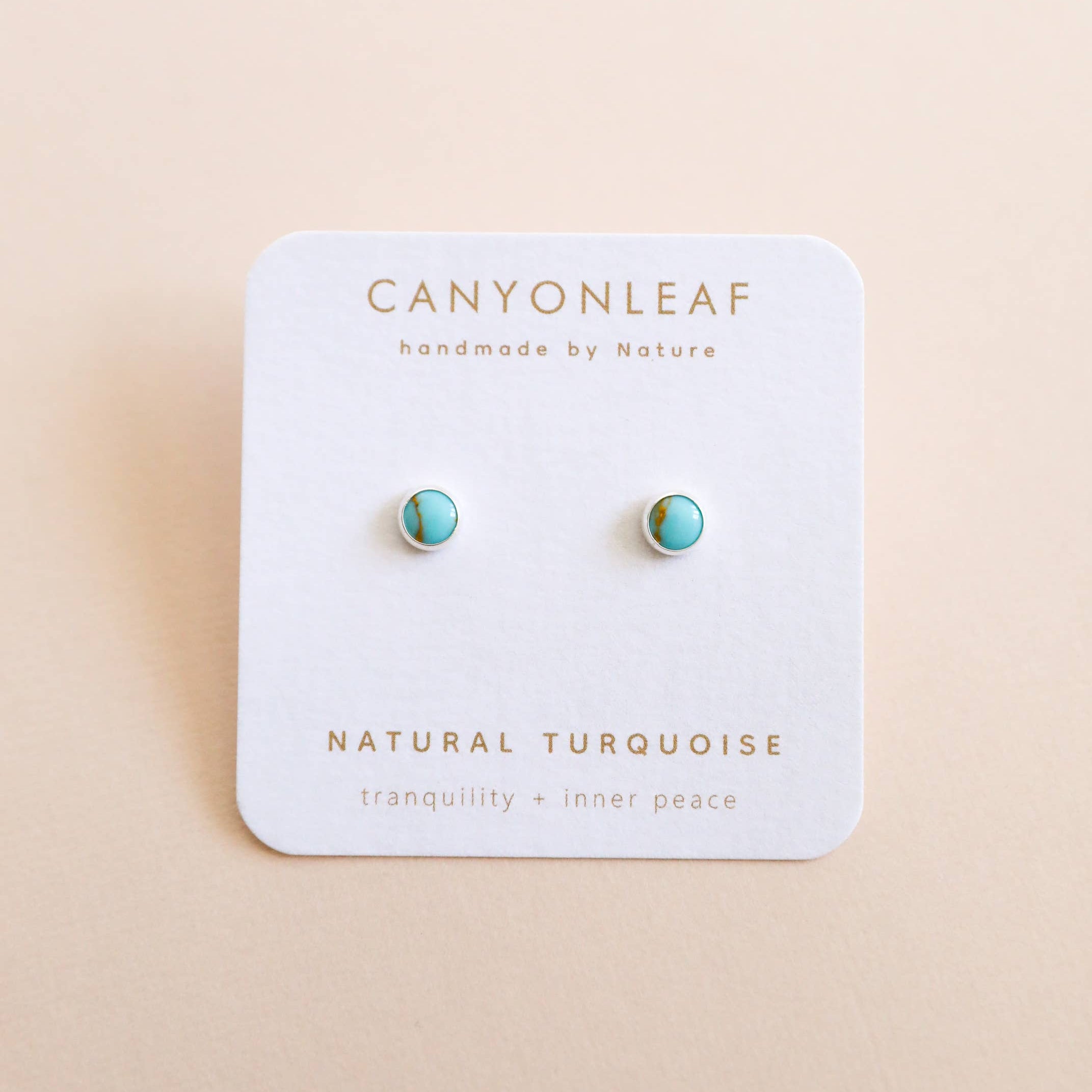 Turquoise earrings on a Canyonleaf branded card with a beige background