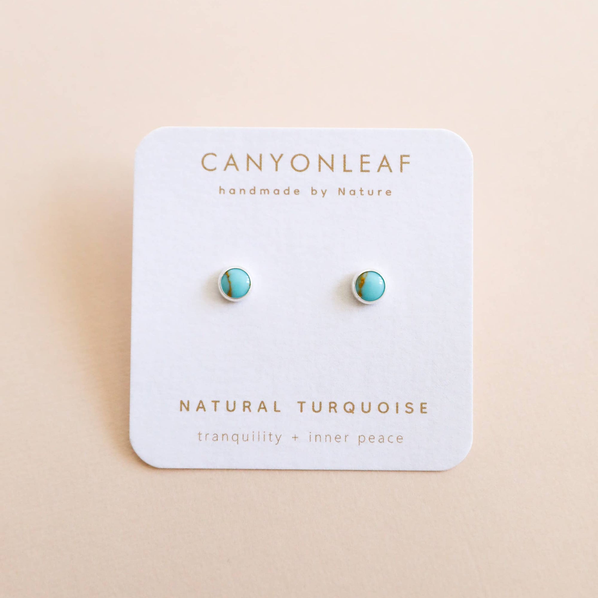 Turquoise earrings on a Canyonleaf branded card with a beige background