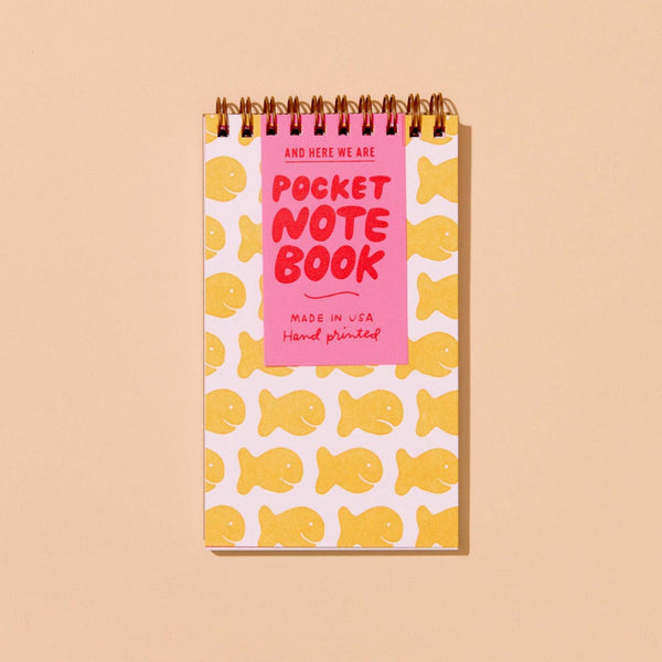 Pocket notebook with yellow fish pattern on a beige background