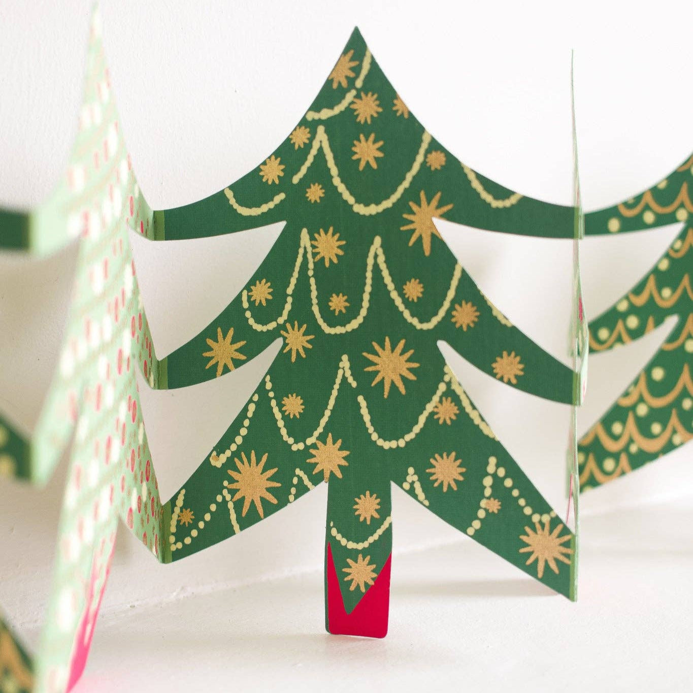Decorative paper Christmas tree with gold ornaments on a white background