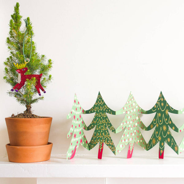 Decorative paper Christmas trees with a potted Christmas tree on a white background