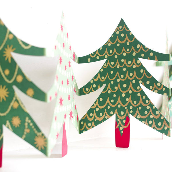 Decorative paper Christmas trees with green, gold, and red patterns on a white background.
