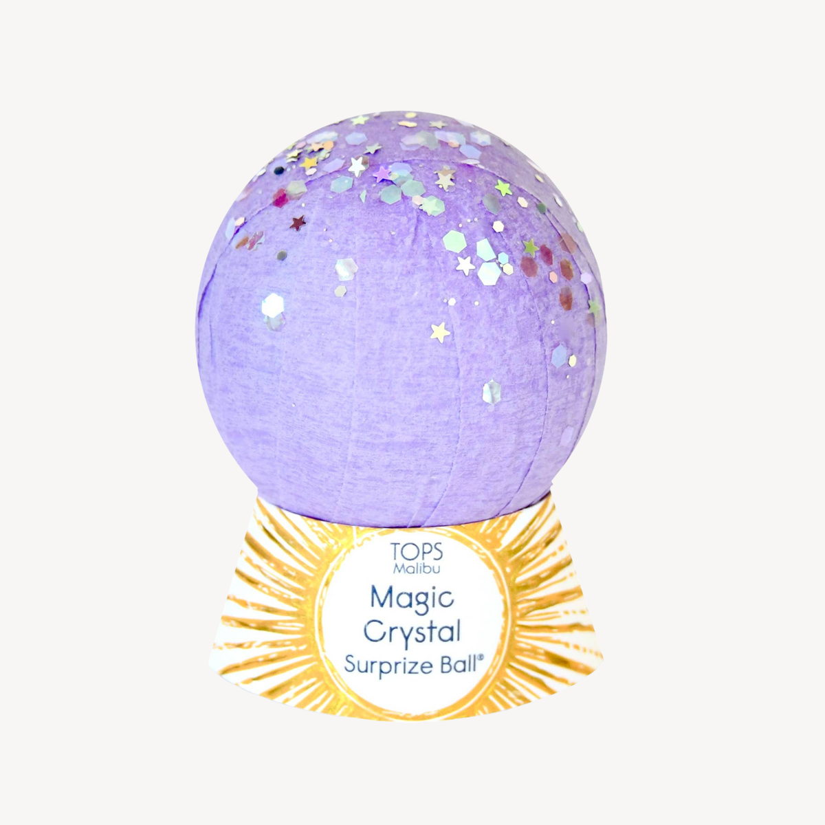 A purple surprise ball with multicolor star and hexagon confetti, displayed on a gold-colored circular stand with the text 'TOPS Magic Magic Crystal Surprise Ball'.