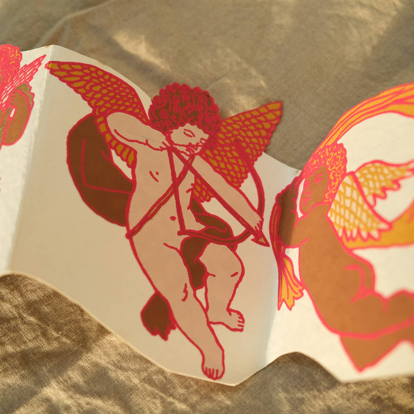 Decorative paper cutout of Cupid on a textured surface