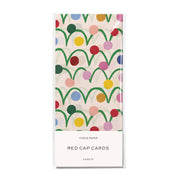 Pack of Red Cap Cards tissue paper with a colorful retro pattern of green arches and multicolored dots on a cream background, sealed in a clear plastic sleeve.